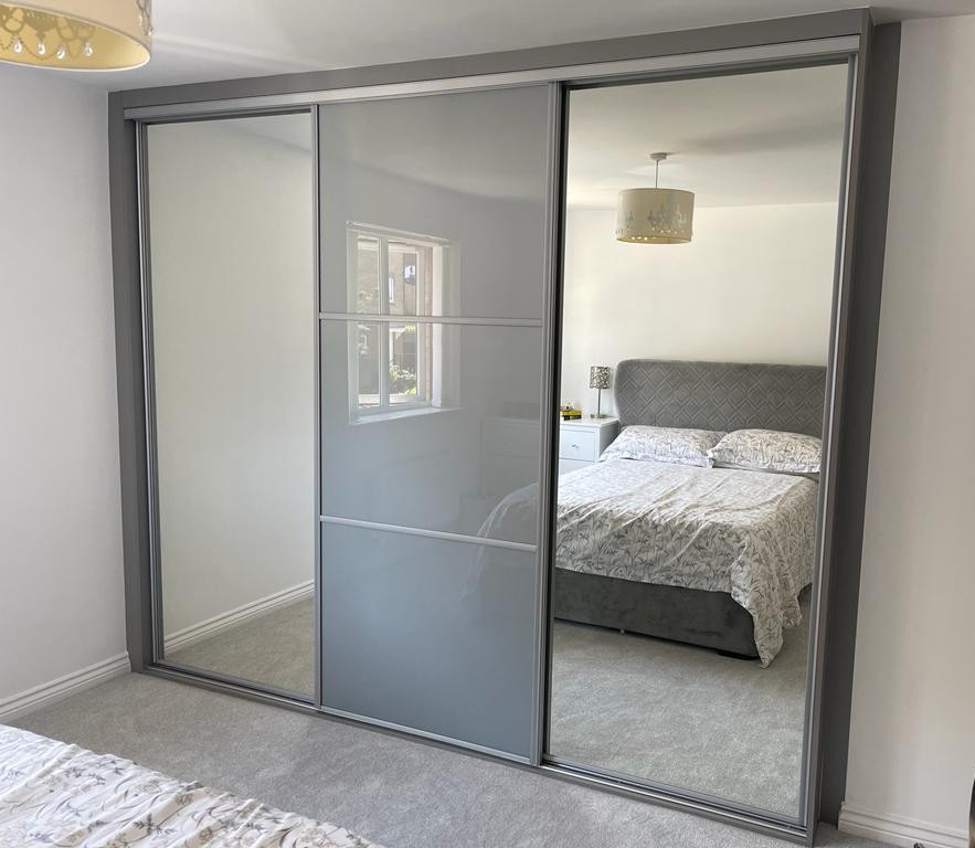 Silver-framed sliding doors with grey glass centre panels between full mirrors in Port Talbot