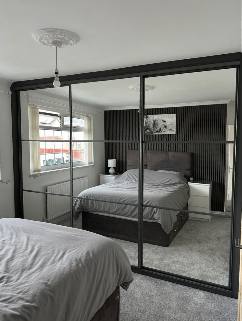 Three-door black-framed mirror wardrobe with horizontal bars in Newport