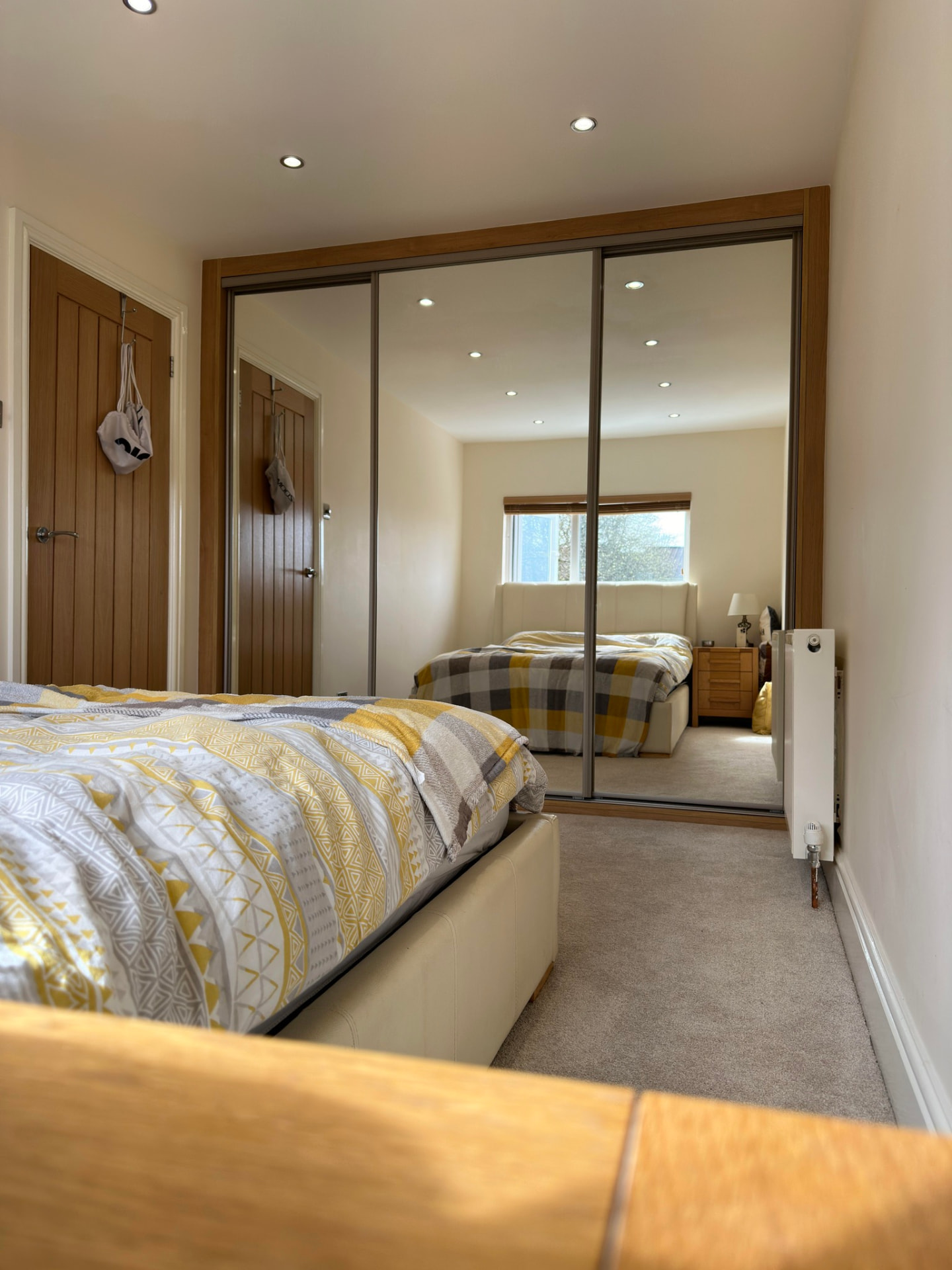 Full-mirror sliding doors set in an oak-effect frame in Llantwit Major