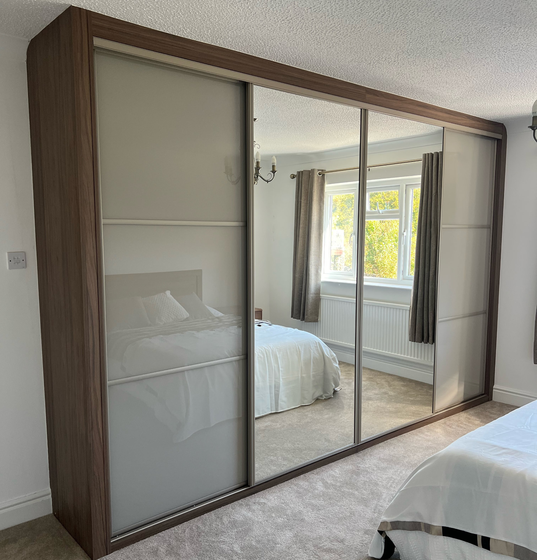 Cream panel and full-height mirror sliding doors in a walnut-effect frame in Port Talbot