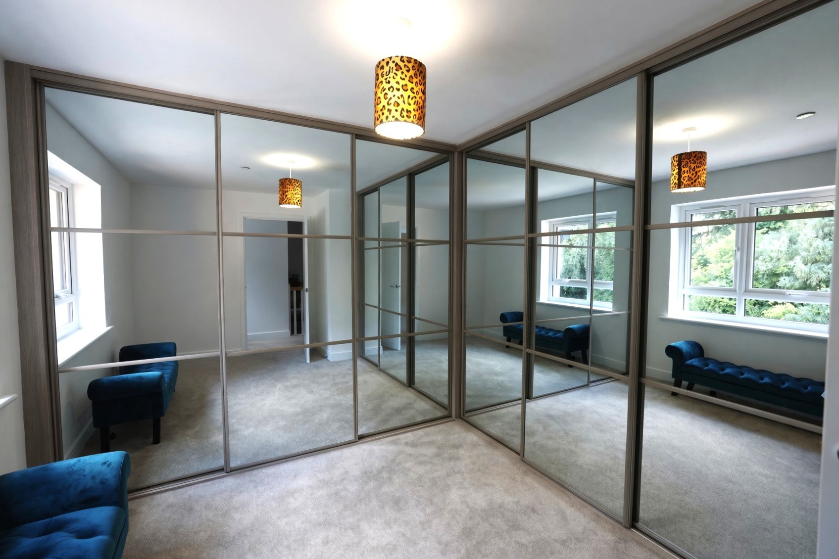 Floor-to-ceiling mirror sliding wardrobe doors in a main bedroom in Cardiff