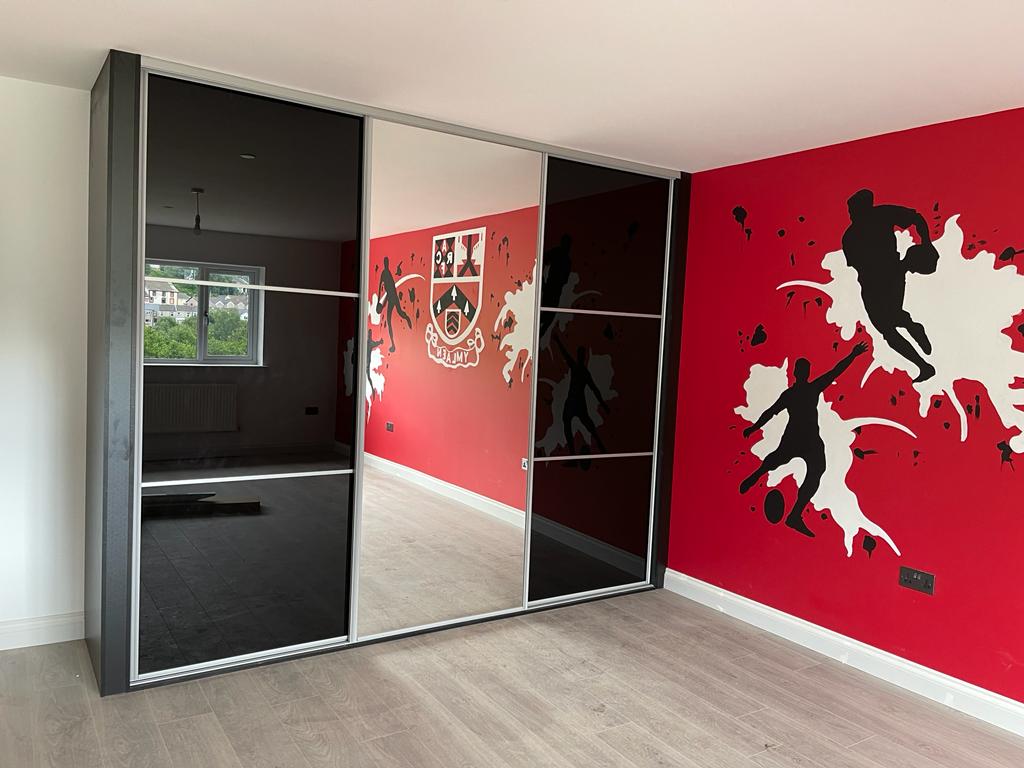 Black glass sliding doors in a rugby-themed room in Cardiff Bay