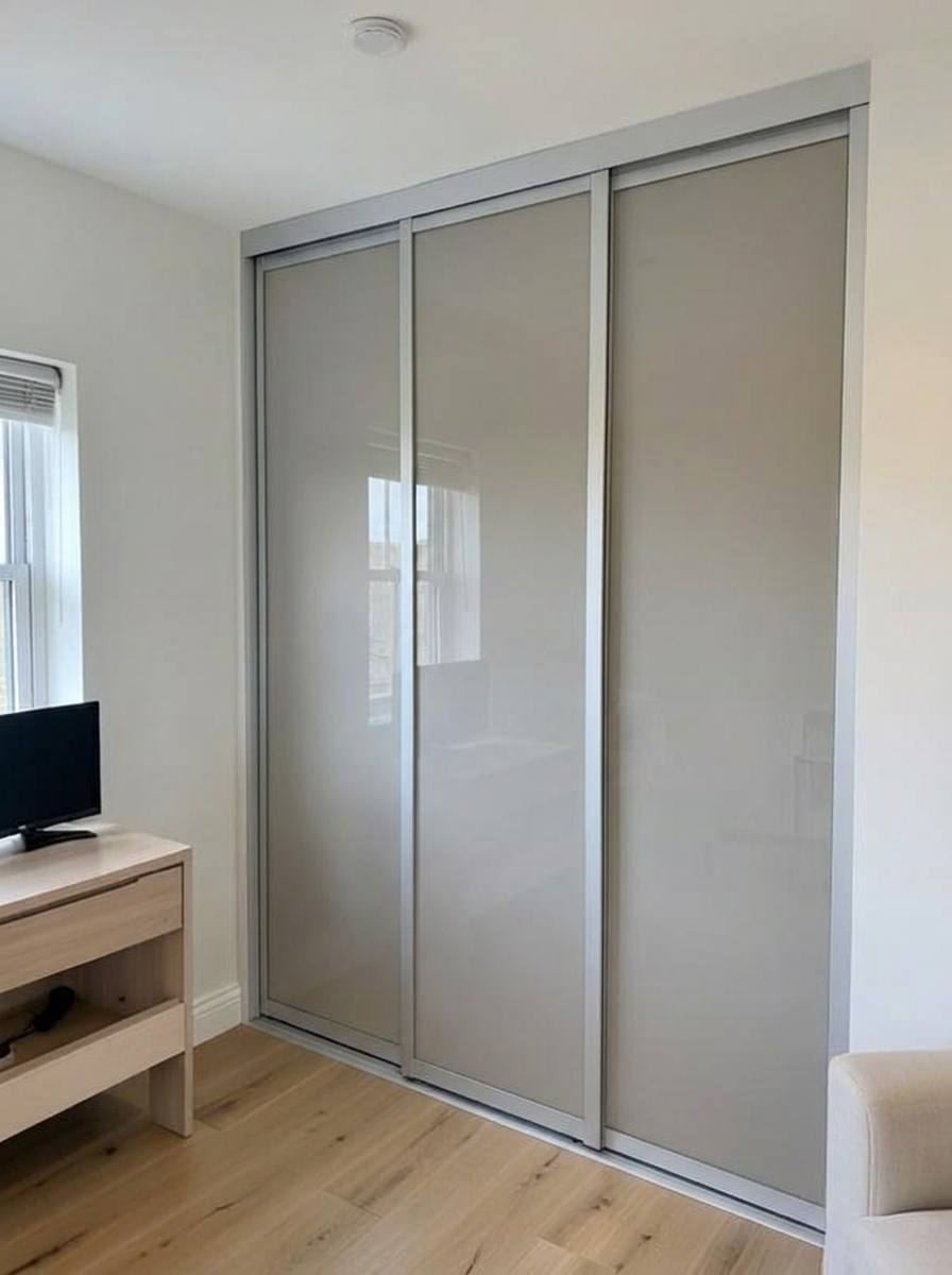 Safety-backed glass sliding wardrobe doors fitted in a family bedroom in South Wales