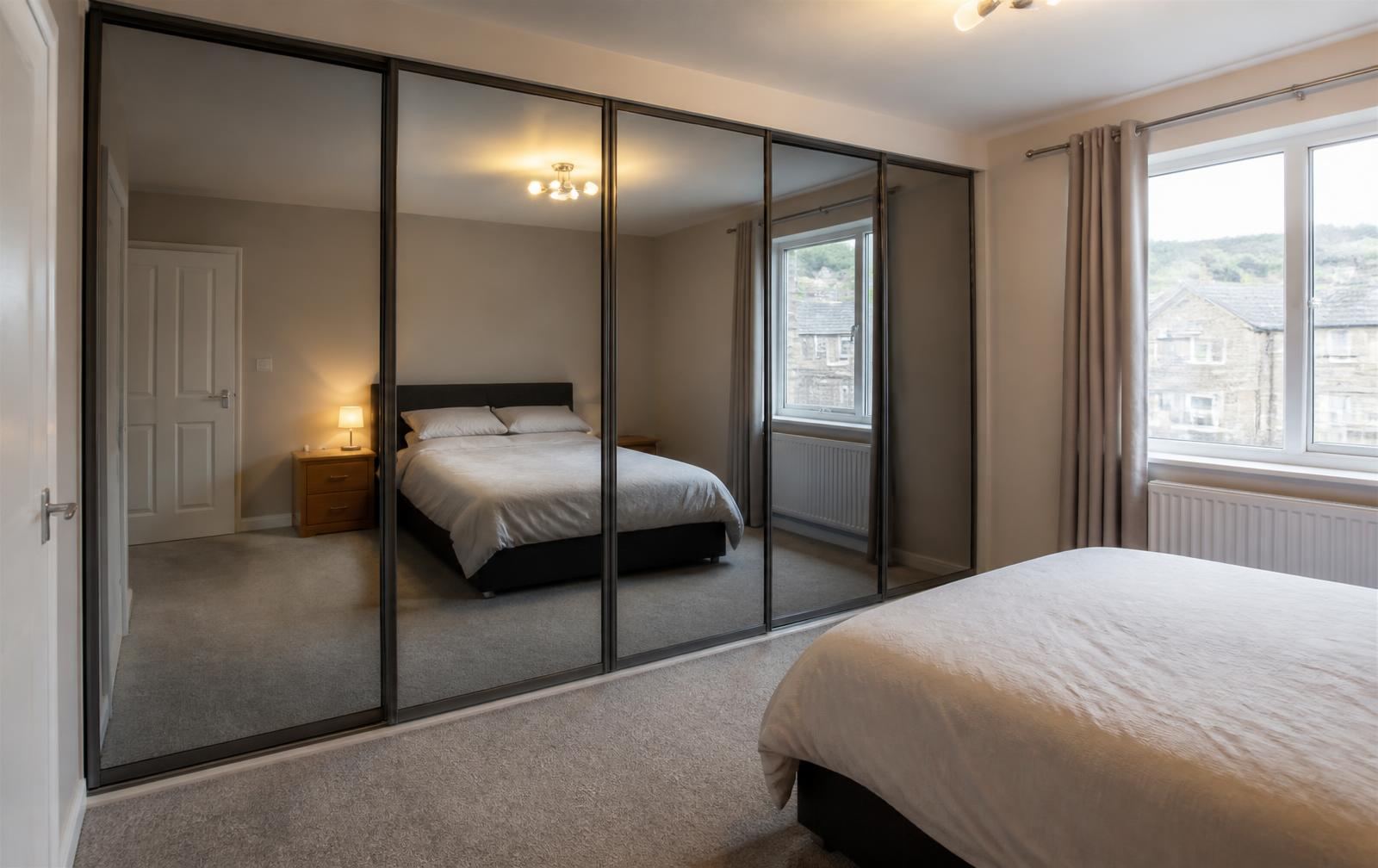 Mirrored sliding wardrobe doors fitted floor to ceiling in a valleys terrace bedroom in Pontypridd